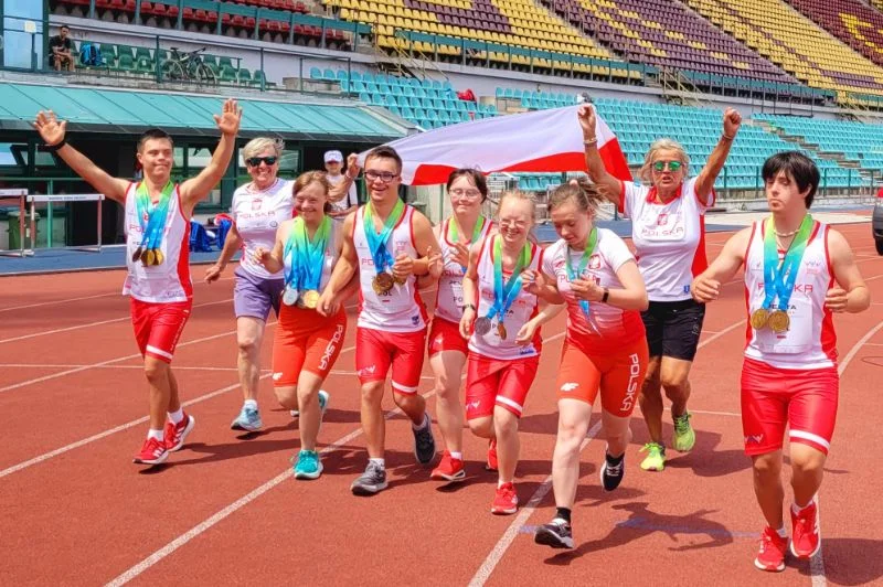 Zawodnicy fundacji Handicap z medalami i flagą Polski